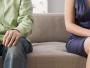 Mid section view of a man and a woman sitting on a couch
